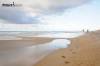 A couple walks goes shelling down the beach on Hatteras Island